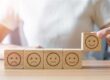 hand choosing smile face from emotion block 2025 03 06 16 02 51 utc