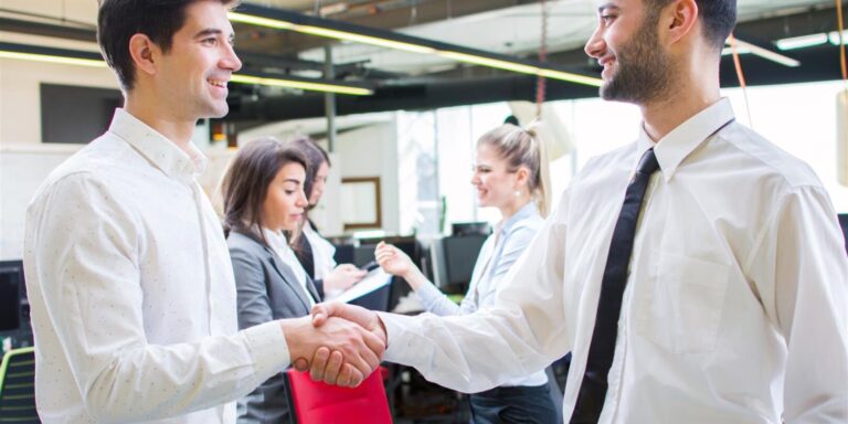 two businessmen shaking hands while standing in th 2026 01 11 11 13 58 utc 1618x809