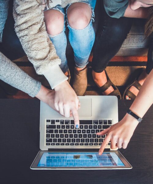 three person pointing the silver laptop computer